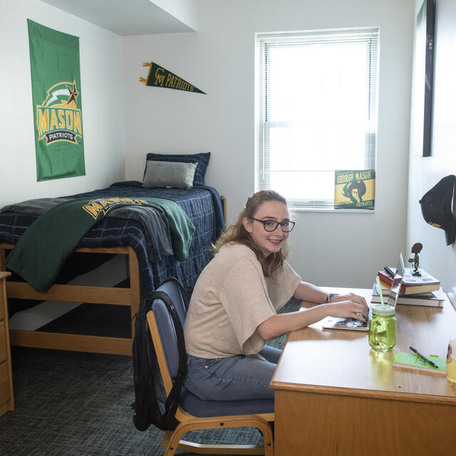student sitting at desk in dorm room