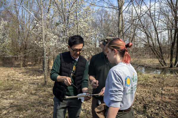 Dr. Changwoo Ahn and two of his students discuss a soil sample