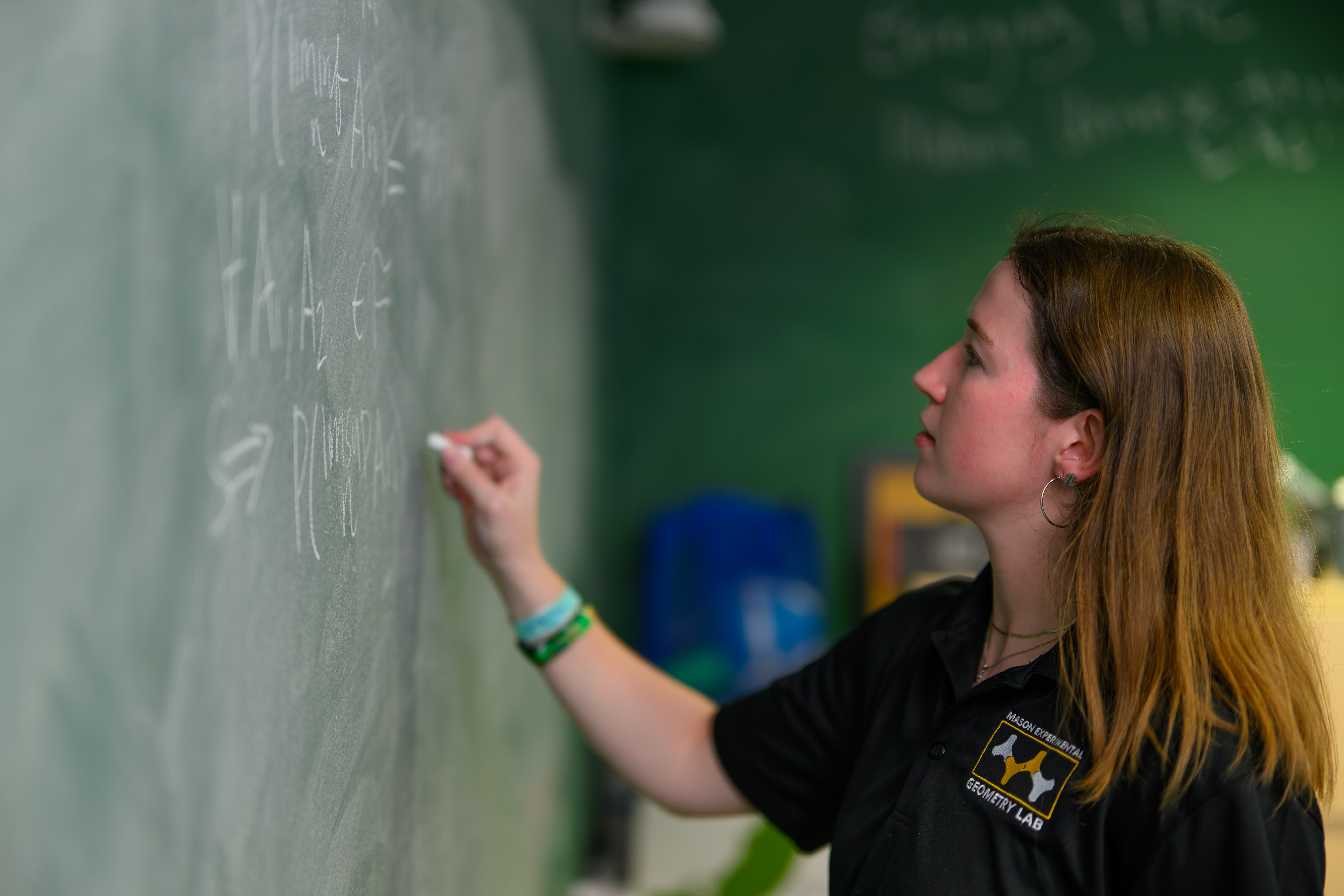 Students writing on chalk board.