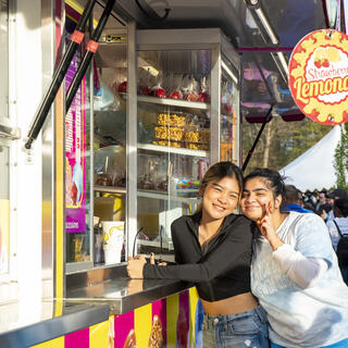 Students posing in front of carnival food