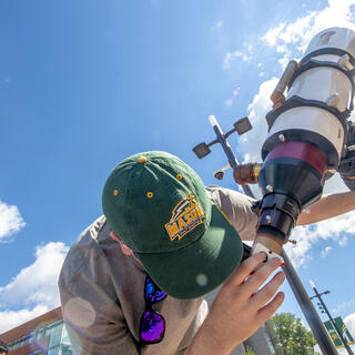 Mason student looking through a telescope
