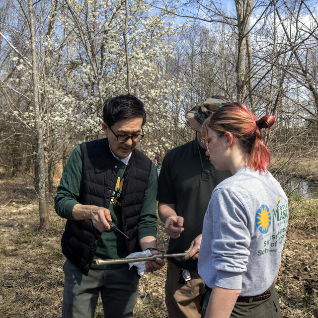 Dr. Changwoo Ahn and two of his students discuss a soil sample