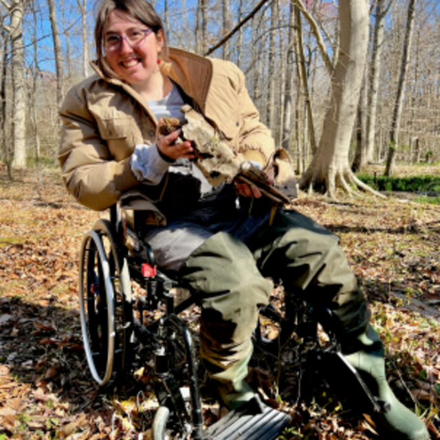 Wren Bell seated in a wheelchair in the field