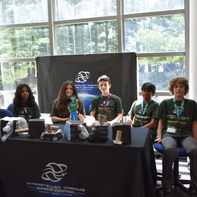 group of young students at table in the Mason Space Center