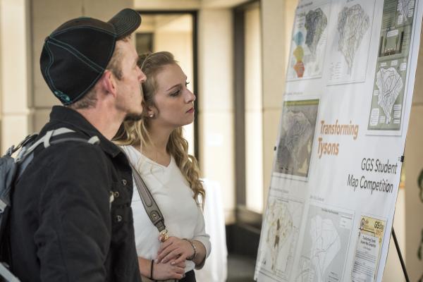 Students look at a GGS student research poster