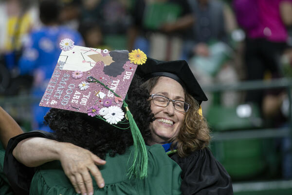 Faculty embraces Student at Graduation Ceremony