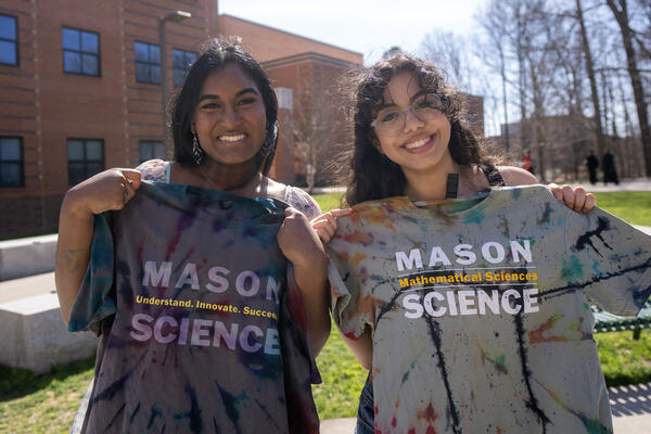 Two girls holding tshirts from Pi Day 2023
