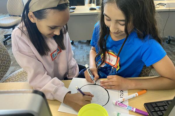 Two campers collaborate on the depiction of Mercury for the Solar System Walk.