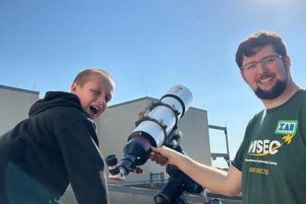 A resized version of the image with Ian and a camper looking at the sun (with precautions taken).