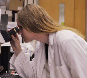 Student Brieann Sobieski using microscope