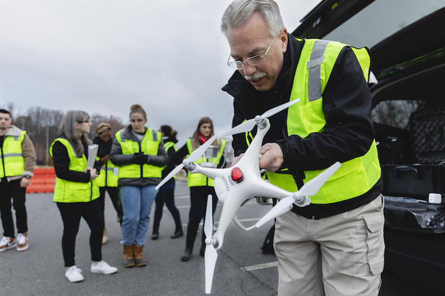 Professor Steven Burmeister sets up an unmanned arial vehicle during his FRSC 516 Forensic Drone Photography class. Photo by Lathan Goumas/Office of Communications and Marketing.