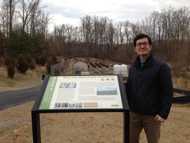 Dr. Changwoo Ahn standing next to the new sign