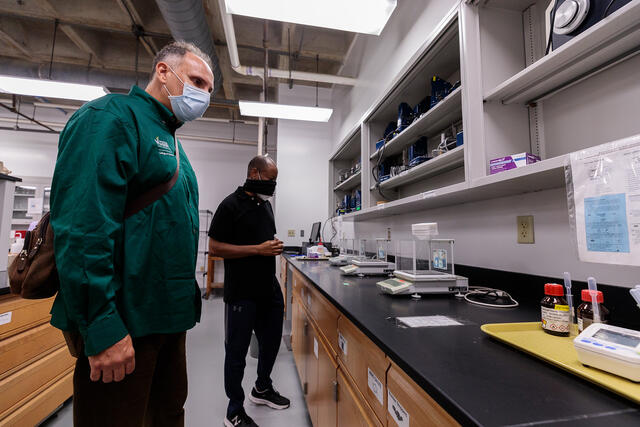 Dean Fernando Miralles Wilhelm reviews the chemistry labs with Gerald Weatherspoon labs