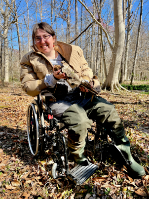Wren Bell seated in a wheelchair in the field