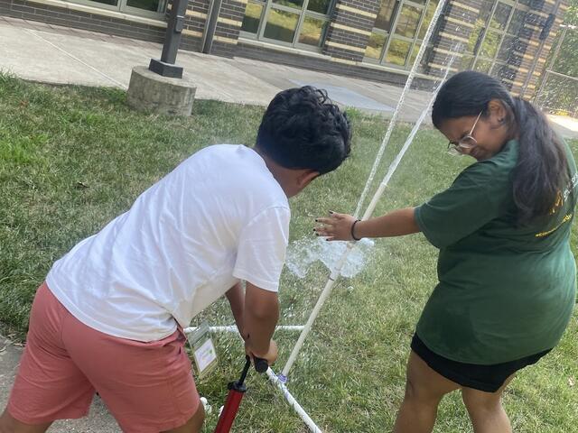 Flight Director Apoorva and a camper successfully launch a water rocket. It appears Apoorva is getting a faceful of rocket exhaust!