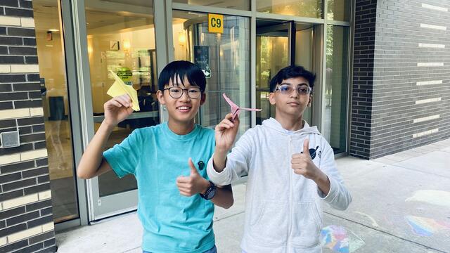 Two campers show off their orbital reentry gliders, ready for testing.