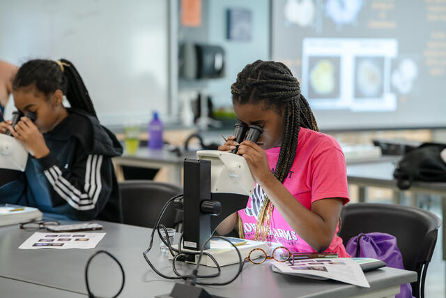 FOCUS students looking through a microscope