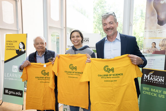 Dean Edwards holds up a college tshirt with CAPMM's Lance Liotta and Marissa Howard