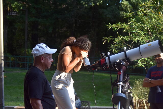 Student looking through telescope at Space Day 2024