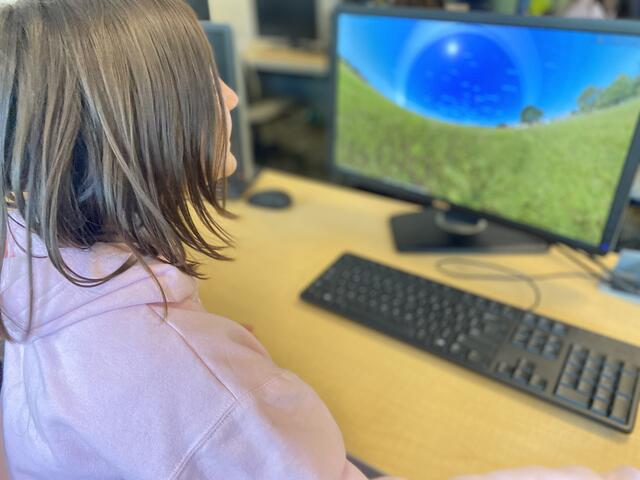 A camper views a Saturn POV of its ring system in the virtual planetarium. 