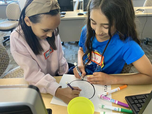 Two campers collaborate on the depiction of Mercury for the Solar System Walk.