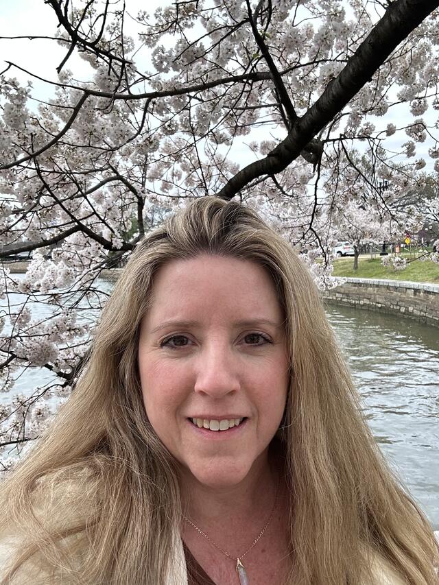 Photo of Adrianna Berk in from of a Cherry Blossom tree