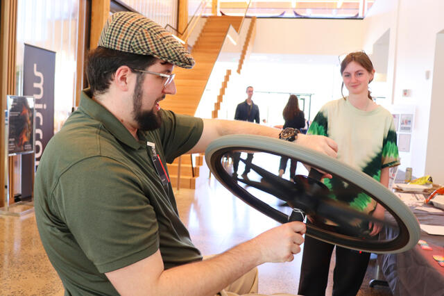 Ian explains why the wheel spins the person on a spinning stool, as seen from a different angle.