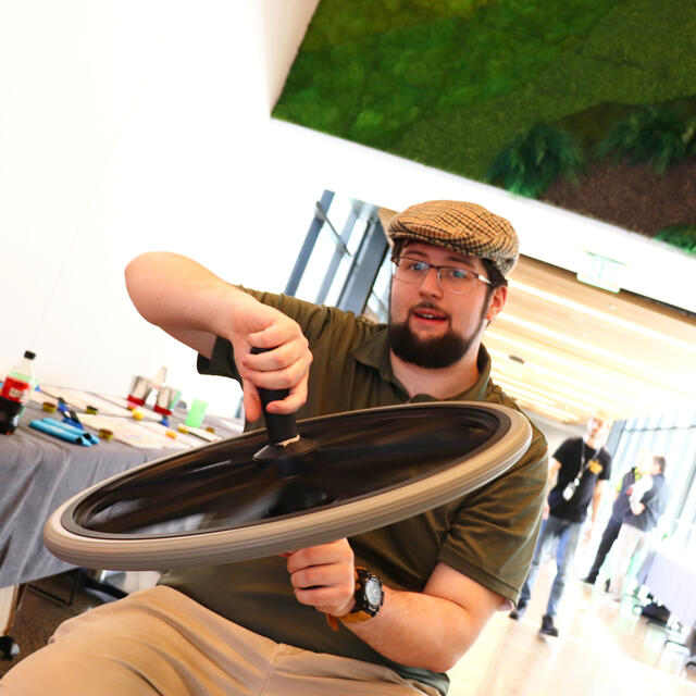 Ian explains why the wheel spins the person on a spinning stool.