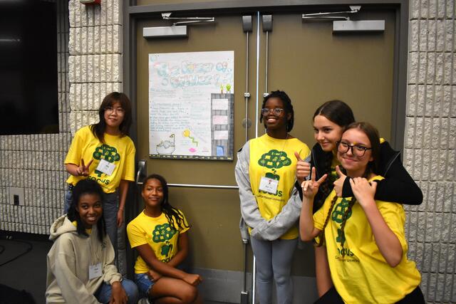 FOCUS participants stand in front of their poster to present the final day.