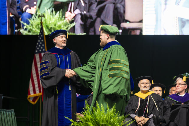 Presentation of the College of Science dissertation medal during the 2025 Degree Celebration for the College of Science at EagleBank Arena. Photo by: Ron Aira/Creative Services/George Mason University