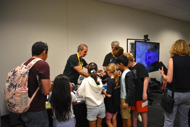 Kids and their parents watch a demonstration by one of the many Space Day vendors.