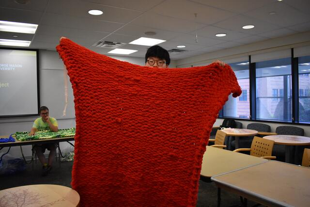 Student shows their completed blanket to be donated to local shelters.