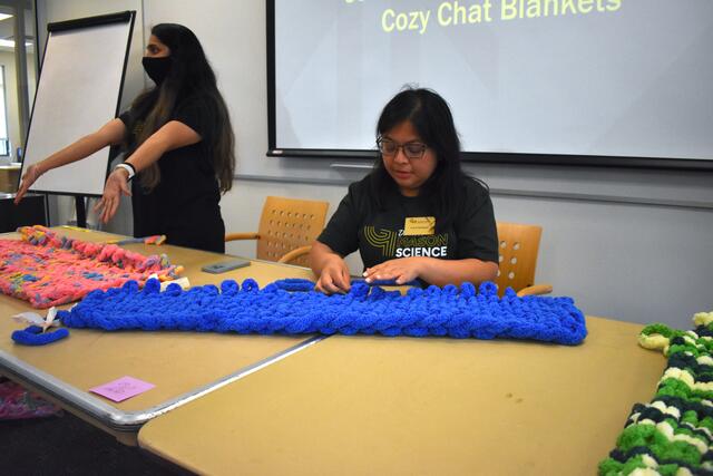 Student creating a blanket to be donated to local shelters.