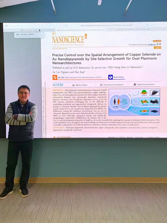 Hao Jing standing in front of a presentation of his research.