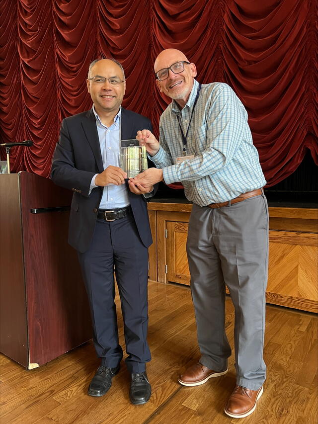 Phil Yang receiving his award from UCGIS President Jeffery Hamerlinck.