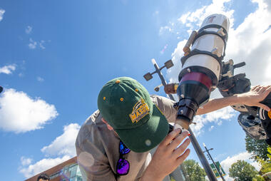 Student looking through telescope