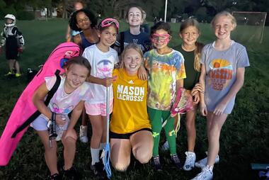 Distad smiles with a group of young lacrosse players