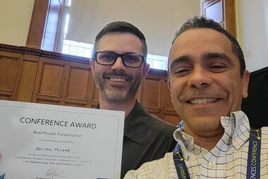 McLeod and Lopez smile with McLeod holding his "best poster" award certificate