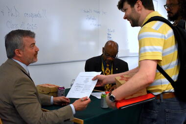 Cody W. Edwards signing off on PhD dissertations and MA theses.. 