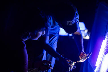 Two participants take photos of insects with the black light