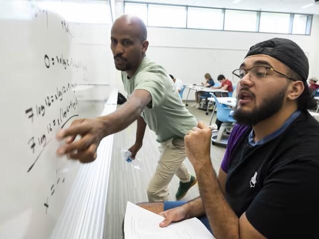 Ermias Kassaye at Whiteboard with student at Math Bootcamp